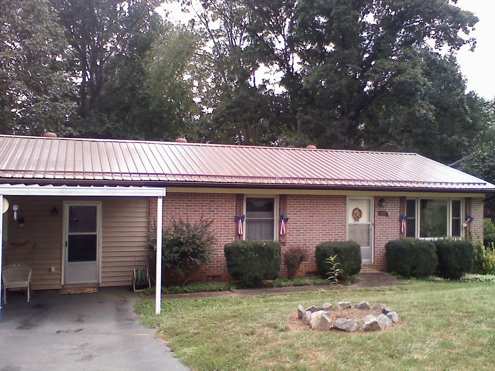 Bronze metal roof and carport on a brick ranch home — Roof Repair work by our crew in Stuart