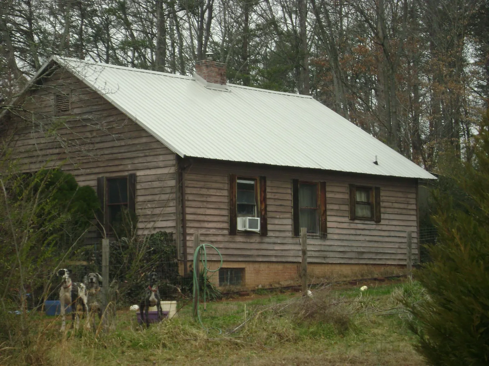 White metal roof on an old wood sided farmhouse, from a Asphalt Shingle Roof Repair job in Stuart
